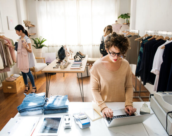 female-business-owner-is-using-laptop Photo of a small fashion brand startup store.